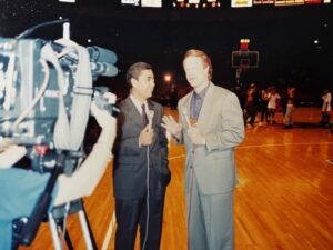 TV camera, anchors reporting on basketball court