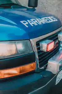 Detailed shot of a blue paramedics ambulance showing the front grill and headlight.