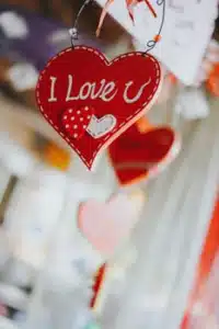 A romantic heart-shaped decoration with "I Love U" text hanging, symbolizing love and affection.